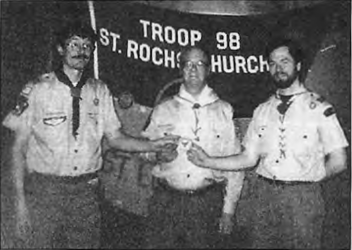 Steve,Art,and Scott Santen show that Scouting is,indeed,a family affair. On February2,1997,Scout Sunday,Scott,right,past Scoutmaster,hands the Scoutmaster patch to his brother Steve who now serves in that role. Their father,Art,is Troop98’s Committee Treasurer. Photographer not credited.