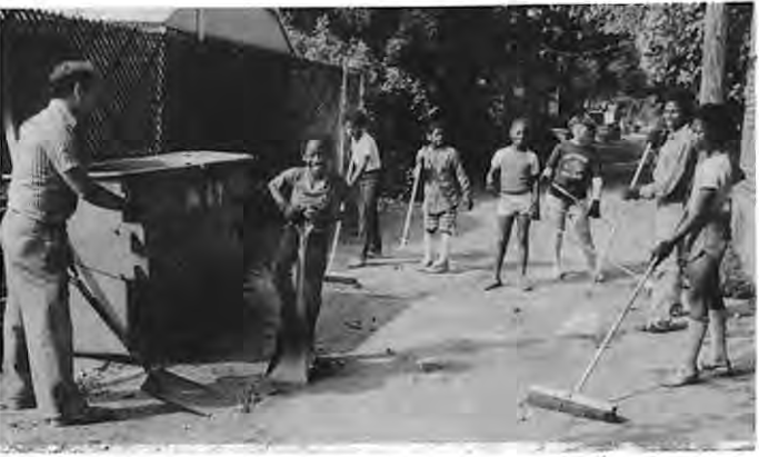 George and Karen Brown direct neighborhood children in 1982 alley cleanup. Photographer not credited.