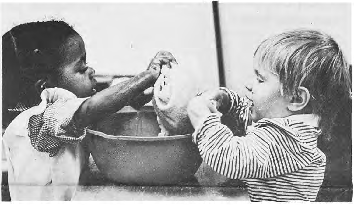 Two young children working together over a bowl at Stella Maris.