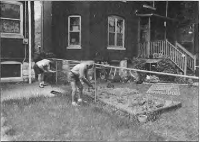 Joe Gruneisen and his father-in-law take down the fence. Photographer not credited.