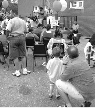 Audience listens at park celebration. Photographer not credited.