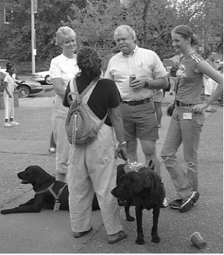 Neighbors gather with dog. Photographer not credited.