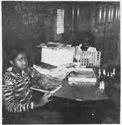 Child using a cassette player in Hamilton’s classroom. No individual identified beyond printed caption.
