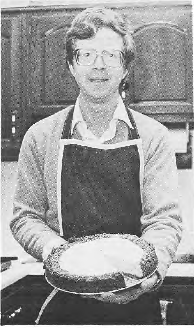 Bob Dowgwillo holding a cheesecake in his kitchen.