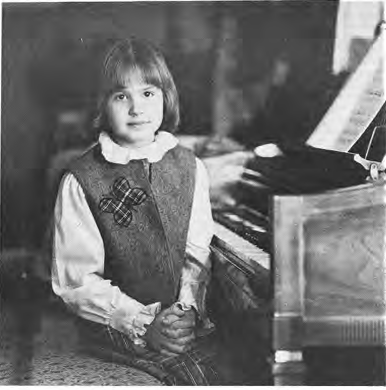 Jocelyn Chapman seated beside a piano.
