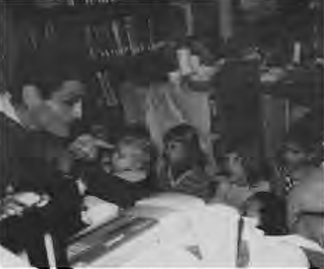 Celebrated Story Teller Bertram Minkin weaves a tale for wee folks at St. Louis Public Library Kiosk. Photographer not credited.