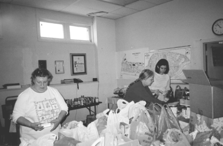 Volunteers sort donated groceries at neighborhood food drive. Photographer not credited.