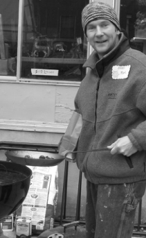 Volunteer preparing food outdoors at Wintermarkt. Photographer not credited.