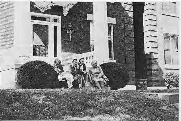 Original photograph from the June 1976 Art Fair photographic spread. Visitors seated on a neighborhood porch.