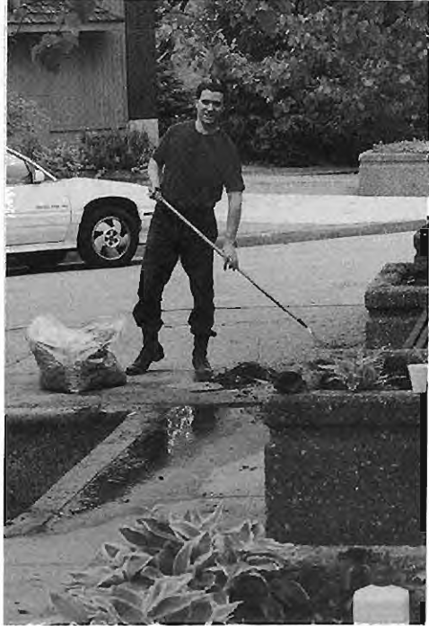 Chris Moritz removes dirt and debris at Four Corners on Blitz Day98. Photographer not credited.