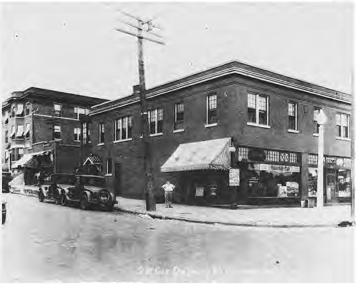 Historic street-corner cafe with automobiles outside.