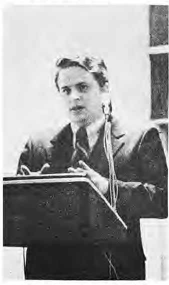 Original photograph of John Roach at a podium.