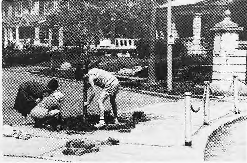 Three volunteers planting by a Rosedale barricade.