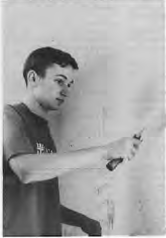 Crossroads student Dan Moore painting at Trinity Church as part of school-wide community service. Photographer not credited.
