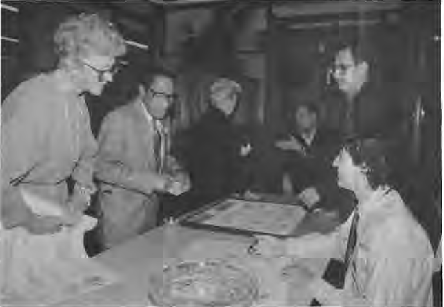 Rose Storey and Horace Busch purchase the Times poster from artist Andy Cross as Roy Roncal looks on. Photo by King Schoenfeld.
