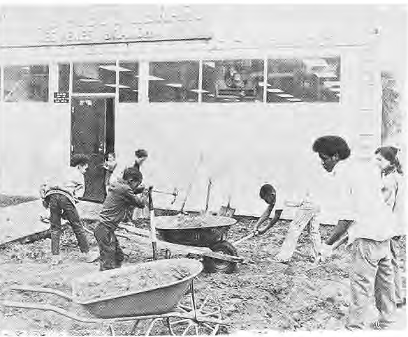Workers making improvements outside the Des Peres Branch Library; the caption names Mrs. Smith, Betty Newsham and Dale.