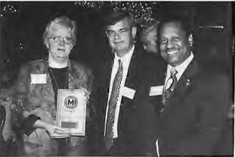JoAnn Vatcha, chair of the SDCC Commercial Committee, and Joe Adams, mayor of University City, receive the Delmar Plan award from Robert Archibald, chair of Citizens for Modern Transit. Photographer not credited.