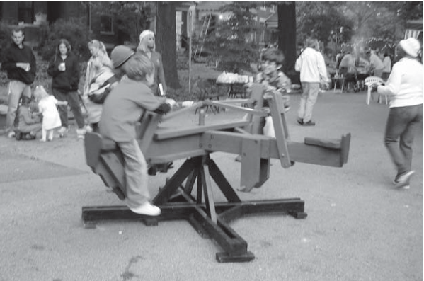 Block-party children enjoy Bill Christman’s old-fashioned whirly-gig.