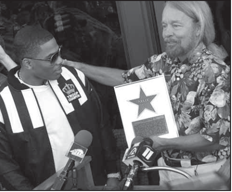 Surprise presentation for Nelly with Joe Edwards. Photographer not credited.
