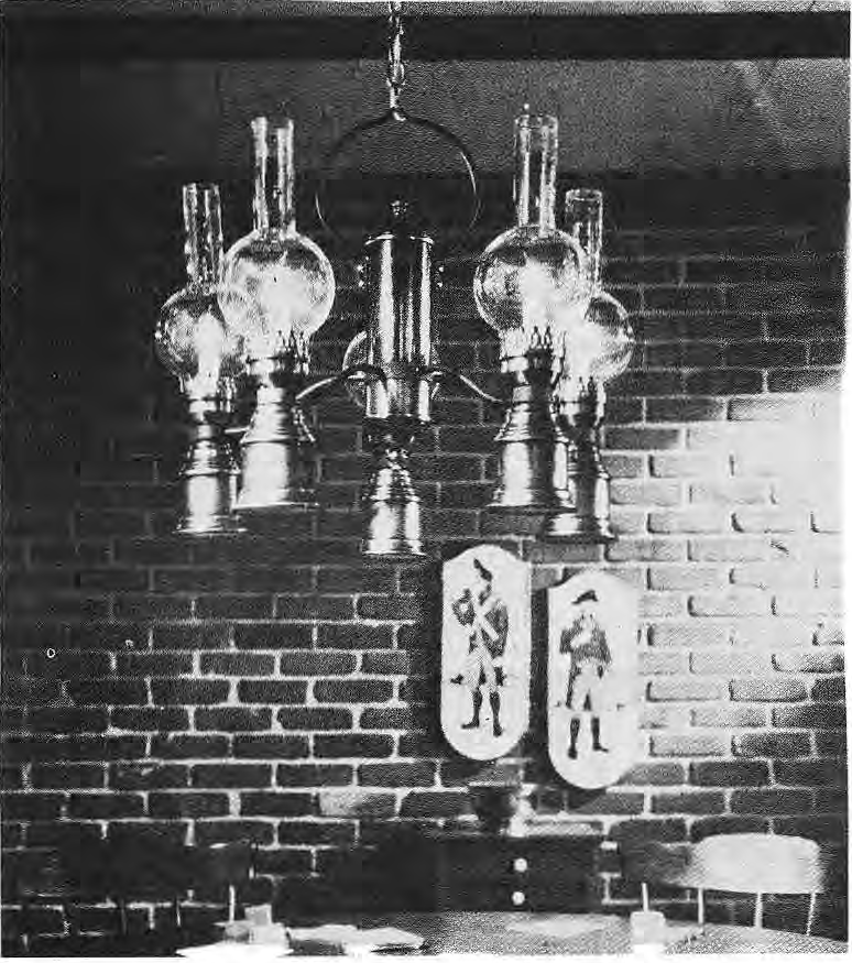 Original photograph of an exposed brick wall and hanging light fixture.