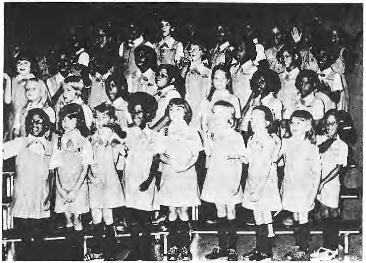 Thirty-six Brownies from Ferguson, Kinloch and St. Louis City sing together in the original choir photograph.