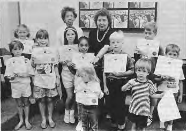 Children holding summer reading certificates.
