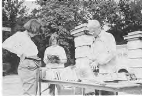 Customers peruse the offerings at The Times’ Book Sale. Reading her New York Times Magazine while minding the store is Lana Stein. Seated to her left is Meg Ullman who also helped out. Photographer not credited.