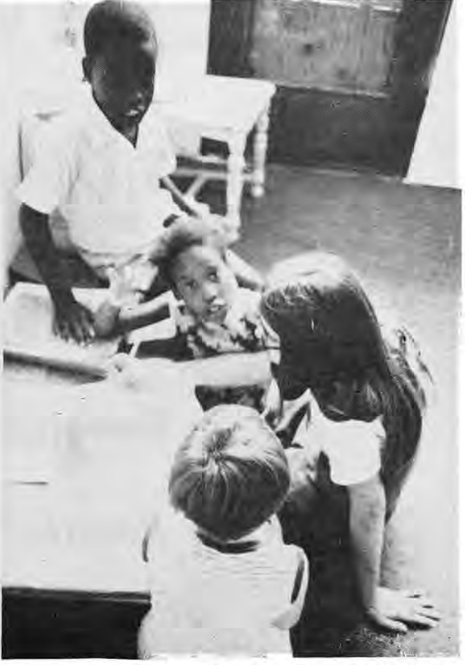 Children in the Something For Summer play school gather round Becky Smith as she reads some of their favorite stories.