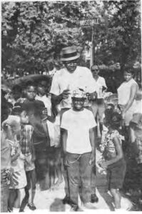 Willis Greeley, then president of the Westminster blocks places a crown on the king of the Westminster block party.