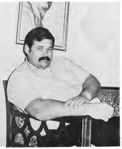 Jim L’Ecuyer seated in a chair