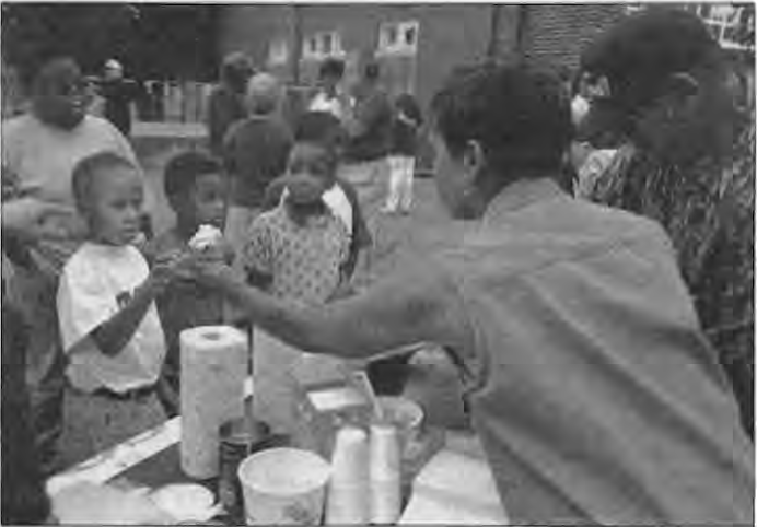 Ice cream booth at National Night Out. December 1997 correction identifies the organizers as the 5900 McPherson block organization, correcting September’s DeGiverville attribution. Photographer not credited.