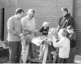 Neighbors Jon Parker, Ute Levi, Katrina Stierholz, and children work on creating tiles for the stage sculpture. Photographer not credited.
