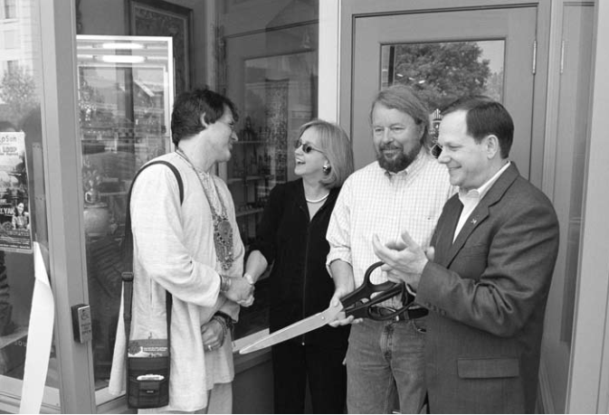 Lyda Krewson congratulates Gil Williams as Joe Edwards cuts ribbon and Mayor Slay applauds. Photographer not credited.