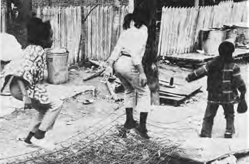 Children using discarded materials to make a trampoline, as described in the original caption.