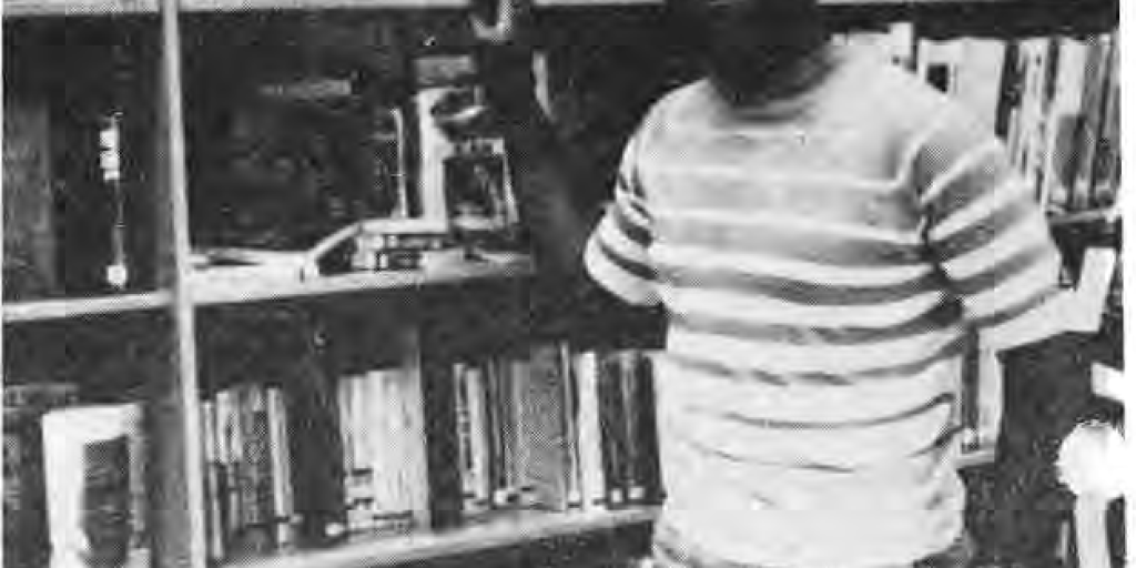 Original photograph accompanying the Charles Brown departure report, showing him standing in the library.