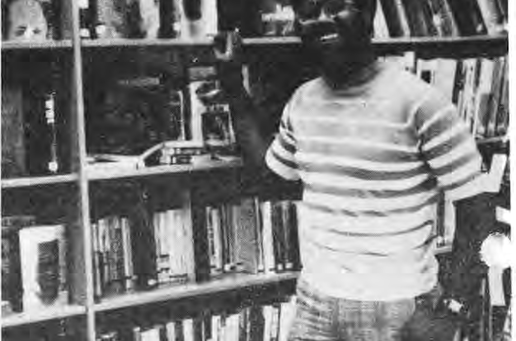 Original photograph accompanying the Charles Brown departure report, showing him standing in the library.