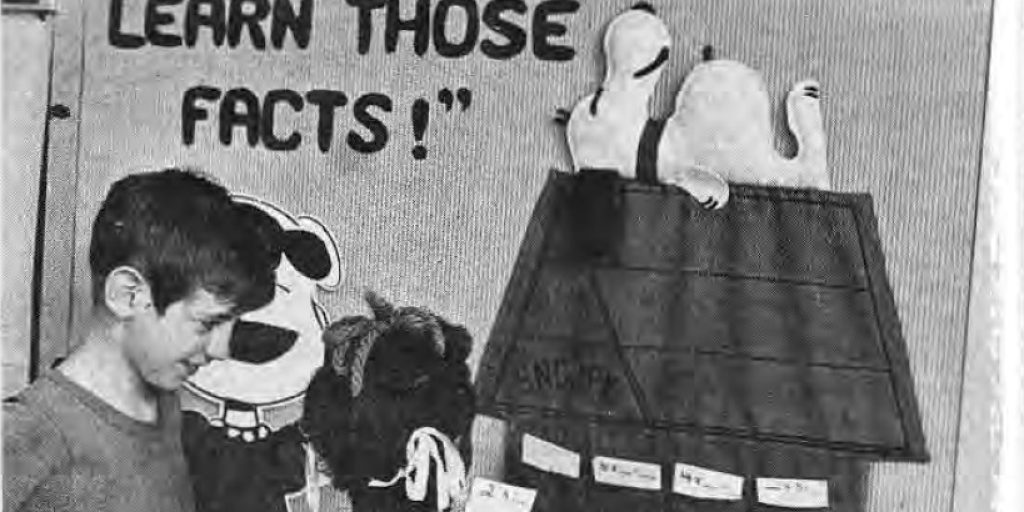 IN MISS LYON’S CLASS even Snoopy helps the children learn in a display which Miss Lyon set up for the children to use when they finish a class assignment. They pick cards with math problems on them from the pockets on Snoopy’s house.