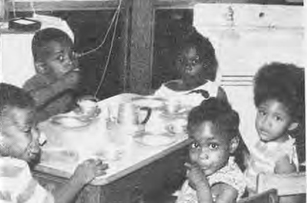 Children at a table in the Project Five Day Care Center