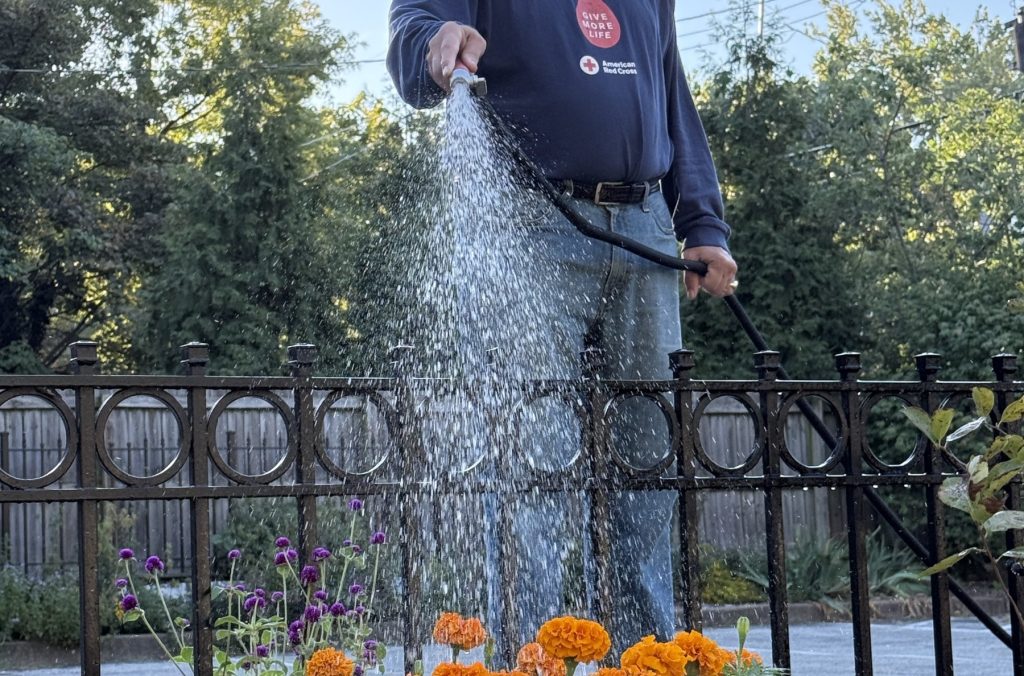 Paul Kurtz waters the Bonafide parking lot garden.